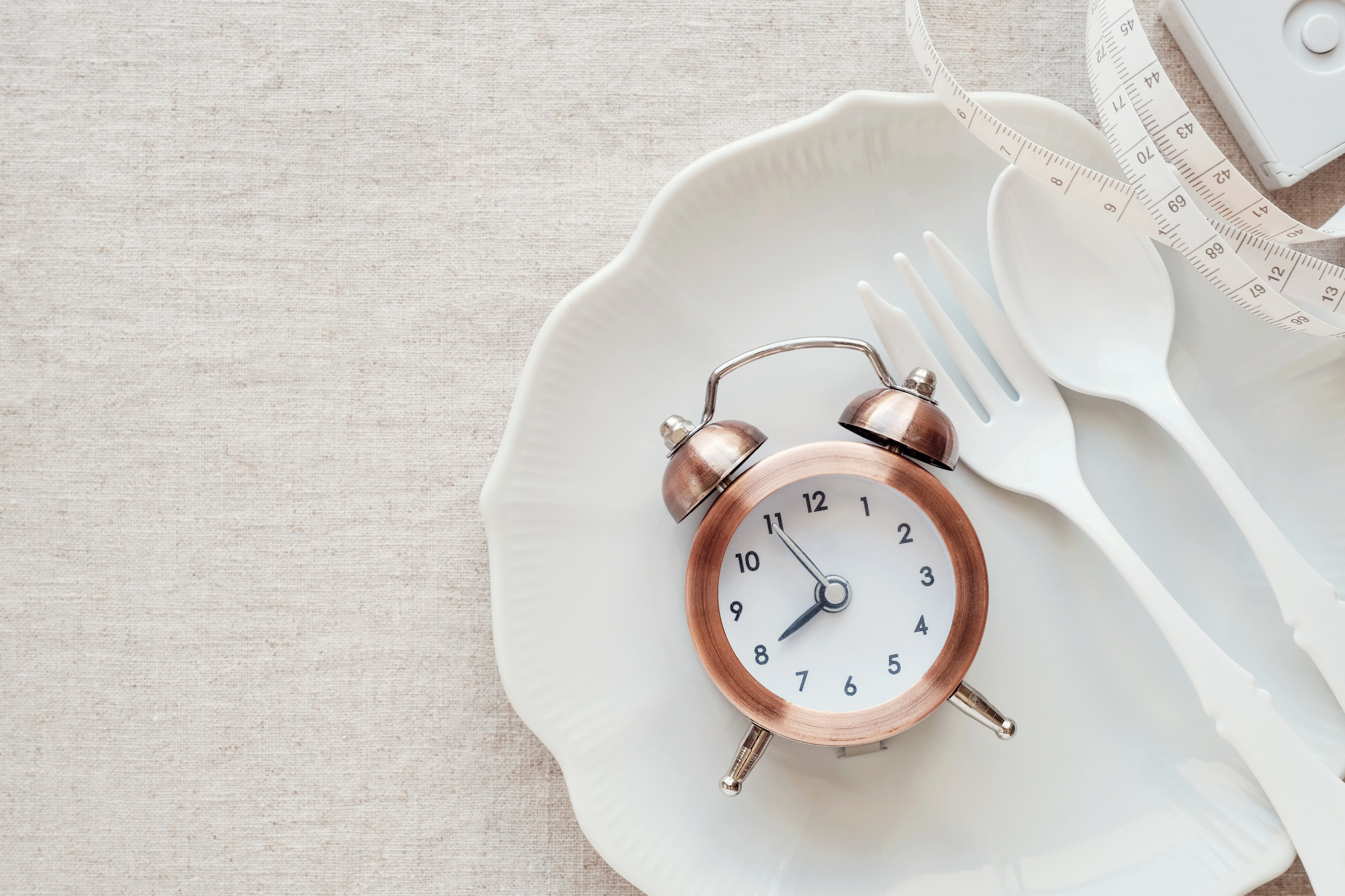 A clock on the plate and tape measure, Intermittent fasting diet concept