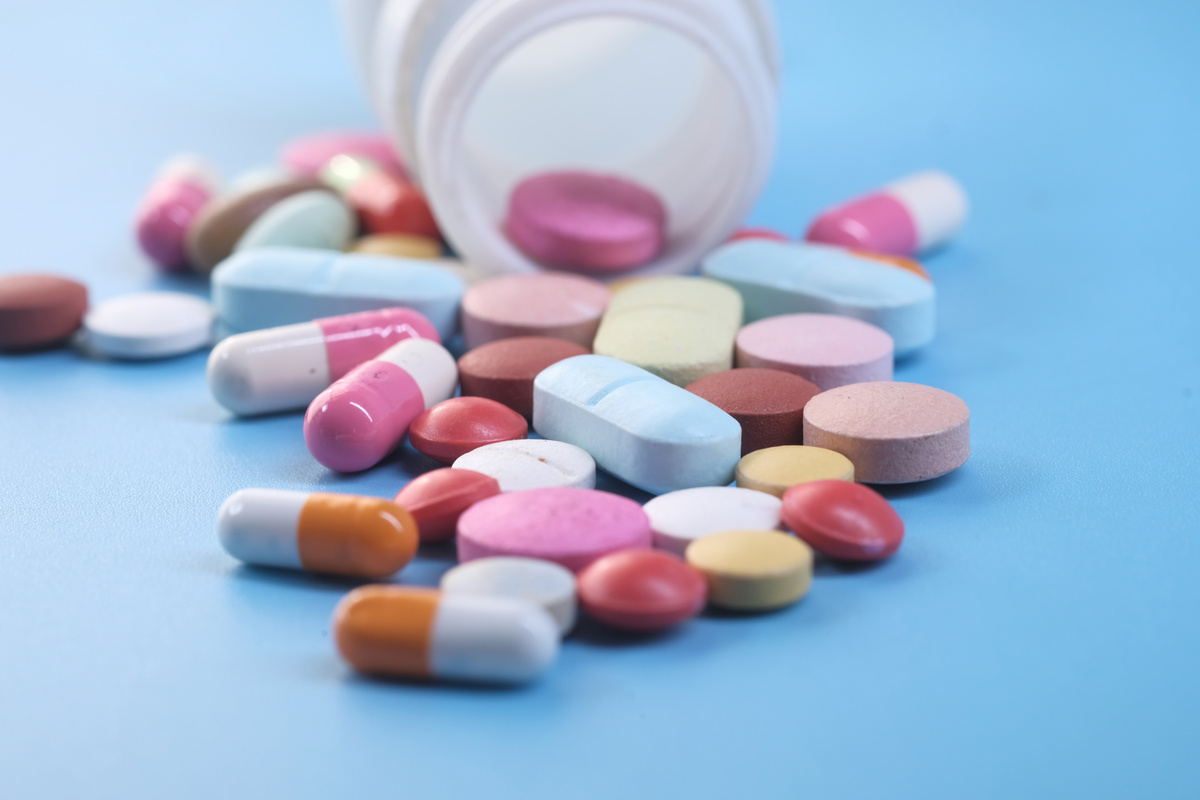 Close up of Colorful Pills Spilling on Blue Background