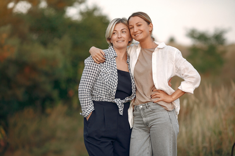 Happy women of different ages hugging in nature